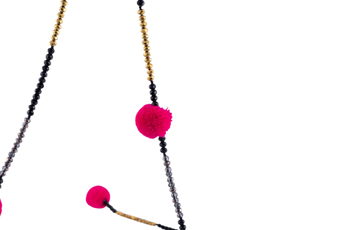 Collana lunga con pon pon decorativi e intreccio di microperline lavorate